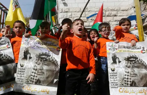 Palestinian children take part in a rally to mark the 13th anniversary of the death of late Palestinian leader Yasser Arafat, in the West Bank city of Hebron, on November 12, 2017. Photo by Wisam Hashlamoun
