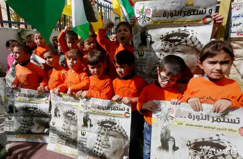 Palestinian children take part in a rally to mark the 13th anniversary of the death of late Palestinian leader Yasser Arafat, in the West Bank city of Hebron, on November 12, 2017. Photo by Wisam Hashlamoun