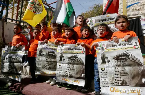 Palestinian children take part in a rally to mark the 13th anniversary of the death of late Palestinian leader Yasser Arafat, in the West Bank city of Hebron, on November 12, 2017. Photo by Wisam Hashlamoun