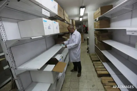 A Palestinian pharmacist stands next shelves which empty from medicines at Al-Shefa Hospital in Gaza City on Nov 16,2017 as Gaza Strip faces a lack of medicines. Photo by Mohammed Asad