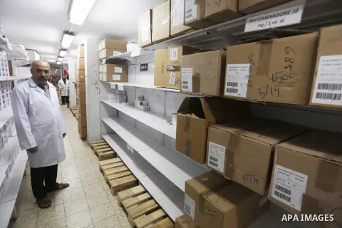 A Palestinian pharmacist stands next shelves which empty from medicines at Al-Shefa Hospital in Gaza City on Nov 16,2017 as Gaza Strip faces a lack of medicines. Photo by Mohammed Asad