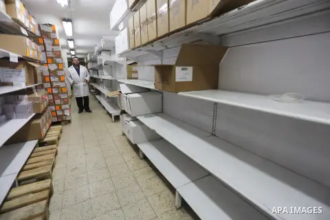 A Palestinian pharmacist stands next shelves which empty from medicines at Al-Shefa Hospital in Gaza City on Nov 16,2017 as Gaza Strip faces a lack of medicines. Photo by Mohammed Asad
