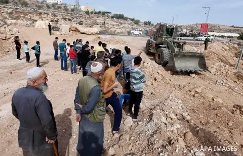 Israeli security forces stand guard as an Israeli army bulldozer closes a road in the West Bank city of Hebron after Palestinian municipality of Hebron reopened the road after 17 years of closure by the Israeli army in t...