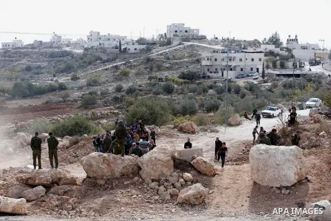 Israeli security forces stand guard as an Israeli army bulldozer closes a road in the West Bank city of Hebron after Palestinian municipality of Hebron reopened the road after 17 years of closure by the Israeli army in t...