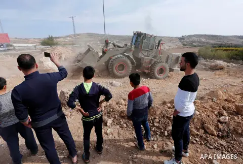 Israeli security forces stand guard as an Israeli army bulldozer closes a road in the West Bank city of Hebron after Palestinian municipality of Hebron reopened the road after 17 years of closure by the Israeli army in t...