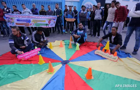 Palestinian graduates hold placards during a protest to demand their rights, in front of the headquarters United Nations Relief and Works Agency (UNRWA) in Gaza city on November 20, 2017. Photo by Mohammed Asad