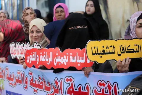 Palestinian graduates hold placards during a protest to demand their rights, in front of the headquarters United Nations Relief and Works Agency (UNRWA) in Gaza city on November 20, 2017. Photo by Mohammed Asad