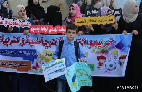 Palestinian graduates hold placards during a protest to demand their rights, in front of the headquarters United Nations Relief and Works Agency (UNRWA) in Gaza city on November 20, 2017. Photo by Mohammed Asad