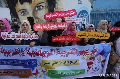Palestinian graduates hold placards during a protest to demand their rights, in front of the headquarters United Nations Relief and Works Agency (UNRWA) in Gaza city on November 20, 2017. Photo by Mohammed Asad