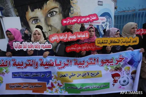 Palestinian graduates hold placards during a protest to demand their rights, in front of the headquarters United Nations Relief and Works Agency (UNRWA) in Gaza city on November 20, 2017. Photo by Mohammed Asad