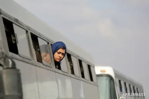 A Palestinian woman looks through a bus window waiting at the Rafah border crossing with Egypt before being allowed to pass out of the southern Gaza Strip on November 20, 2017, following its opening for three days for th...