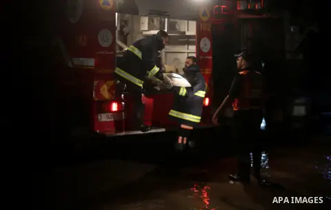 Members of Palestinian Civil Defence work in a flooded street with sewage during a winter storm in Gaza City, on November 27, 2017. Photo by Mohammed Asad