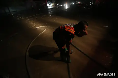Members of Palestinian Civil Defence work in a flooded street with sewage during a winter storm in Gaza City, on November 27, 2017. Photo by Mohammed Asad