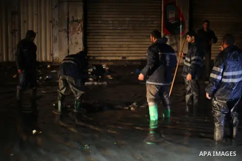 Members of Palestinian Civil Defence work in a flooded street with sewage during a winter storm in Gaza City, on November 27, 2017. Photo by Mohammed Asad