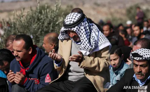 Palestinians perform Friday prayer at the site that where a Palestinian Mahmoud Odeh, 48, was shot dead by an Israeli settler yesterday, in the northern village of Qusra in the occupied West Bank near Nablus on December...