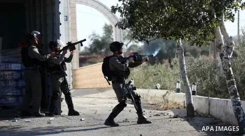 Israeli soldiers aim a tear gas towards Palestinian protesters during clashes in the northern village of Qusra in the occupied West Bank near Nablus on December 1, 2017. Yesterday a Palestinian farmer Mahmoud Odeh, 48, w...