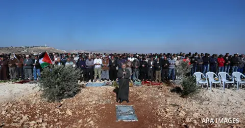 Palestinians perform Friday prayer at the site that where a Palestinian Mahmoud Odeh, 48, was shot dead by an Israeli settler yesterday, in the northern village of Qusra in the occupied West Bank near Nablus on December...