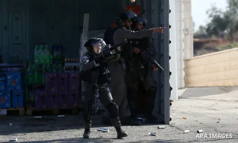 An Israeli soldier aims a tear gas towards Palestinian protesters during clashes in the northern village of Qusra in the occupied West Bank near Nablus on December 1, 2017. Yesterday a Palestinian farmer Mahmoud Odeh, 48...