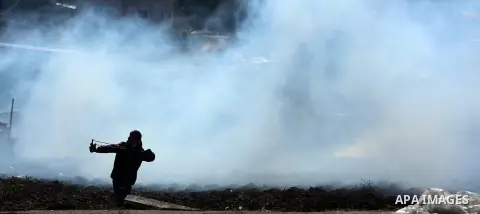 A Palestinian protester uses a slingshot to hurl stones towards Israeli security forces during clashes in the northern village of Qusra in the occupied West Bank near Nablus on December 1, 2017. Yesterday a Palestinian f...