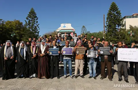 Palestinian employees of Gaza strip hold banners during a protest demanding their rights, in Gaza city, on December 4, 2017. Photo by Ashraf Amra