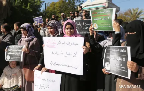 Palestinian employees of Gaza strip hold banners during a protest demanding their rights, in Gaza city, on December 4, 2017. Photo by Ashraf Amra