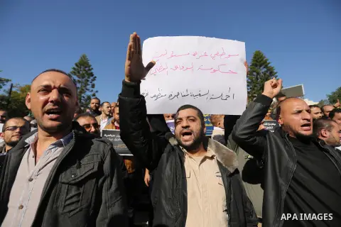 Palestinian employees of Gaza strip hold banners during a protest demanding their rights, in Gaza city, on December 4, 2017. Photo by Ashraf Amra