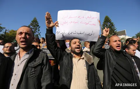 Palestinian employees of Gaza strip hold banners during a protest demanding their rights, in Gaza city, on December 4, 2017. Photo by Ashraf Amra