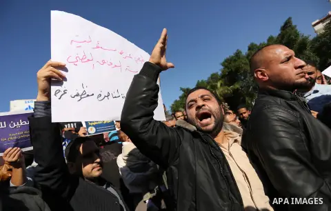 Palestinian employees of Gaza strip hold banners during a protest demanding their rights, in Gaza city, on December 4, 2017. Photo by Ashraf Amra