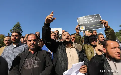 Palestinian employees of Gaza strip hold banners during a protest demanding their rights, in Gaza city, on December 4, 2017. Photo by Ashraf Amra