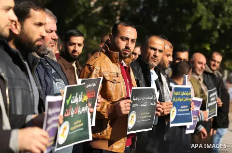Palestinian employees of Gaza strip hold banners during a protest demanding their rights, in Gaza city, on December 4, 2017. Photo by Ashraf Amra