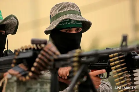 Members of the Ezzedine al-Qassam Brigades, the military wing of the Palestinian Islamist movement Hamas take part during a military parade ahead of the 30th anniversary of Hamas' founding, in Khan Younis in the southern...
