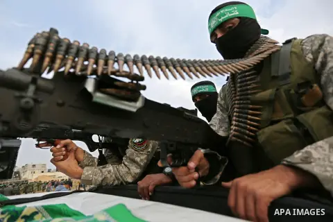 Members of the Ezzedine al-Qassam Brigades, the military wing of the Palestinian Islamist movement Hamas take part during a military parade ahead of the 30th anniversary of Hamas' founding, in Khan Younis in the southern...