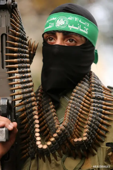 Members of the Ezzedine al-Qassam Brigades, the military wing of the Palestinian Islamist movement Hamas take part during a military parade ahead of the 30th anniversary of Hamas' founding, in Khan Younis in the southern...