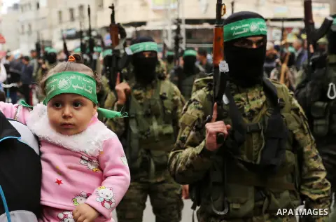 Members of the Ezzedine al-Qassam Brigades, the military wing of the Palestinian Islamist movement Hamas take part during a military parade ahead of the 30th anniversary of Hamas' founding, in Khan Younis in the southern...
