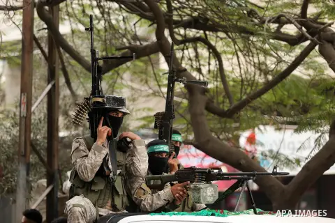 Members of the Ezzedine al-Qassam Brigades, the military wing of the Palestinian Islamist movement Hamas take part during a military parade ahead of the 30th anniversary of Hamas' founding, in Khan Younis in the southern...