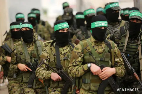 Members of the Ezzedine al-Qassam Brigades, the military wing of the Palestinian Islamist movement Hamas take part during a military parade ahead of the 30th anniversary of Hamas' founding, in Khan Younis in the southern...