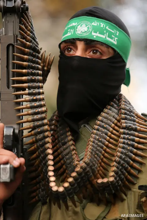 Members of the Ezzedine al-Qassam Brigades, the military wing of the Palestinian Islamist movement Hamas take part during a military parade ahead of the 30th anniversary of Hamas' founding, in Khan Younis in the southern...