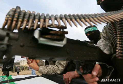 Members of the Ezzedine al-Qassam Brigades, the military wing of the Palestinian Islamist movement Hamas take part during a military parade ahead of the 30th anniversary of Hamas' founding, in Khan Younis in the southern...
