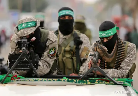 Members of the Ezzedine al-Qassam Brigades, the military wing of the Palestinian Islamist movement Hamas take part during a military parade ahead of the 30th anniversary of Hamas' founding, in Khan Younis in the southern...