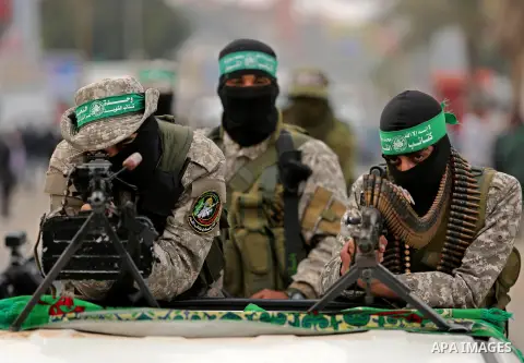 Members of the Ezzedine al-Qassam Brigades, the military wing of the Palestinian Islamist movement Hamas take part during a military parade ahead of the 30th anniversary of Hamas' founding, in Khan Younis in the southern...