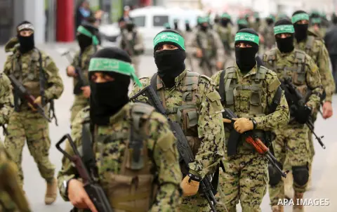 Members of the Ezzedine al-Qassam Brigades, the military wing of the Palestinian Islamist movement Hamas take part during a military parade ahead of the 30th anniversary of Hamas' founding, in Khan Younis in the southern...
