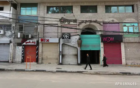 A Palestinian man walks past closed shops during a general strike over U.S. President Donald Trump's decision to recognize Jerusalem as the capital of Israel, in the Gaza city on December 7, 2017. Photo by Ashraf Amra
