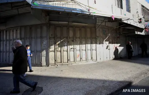 Palestinians walk past closed shops during a general strike over U.S. President Donald Trump's decision to recognize Jerusalem as the capital of Israel, in the West bank city of Nablus on December 7, 2017. Photo by Ayman...