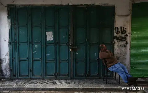 Palestinians walk past closed shops during a general strike over U.S. President Donald Trump's decision to recognize Jerusalem as the capital of Israel, in the West bank city of Nablus on December 7, 2017. Photo by Shadi...