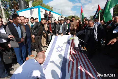 Palestinian protesters burn US and Israeli flags following Trump's decision to recognise Jerusalem as the capital of Israel, in front of the headquarter United Nation "UNSCO" in Gaza City, on December 7, 2017. Photo by M...