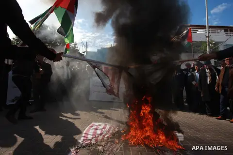 Palestinian protesters burn US and Israeli flags following Trump's decision to recognise Jerusalem as the capital of Israel, in front of the headquarter United Nation "UNSCO" in Gaza City, on December 7, 2017. Photo by M...