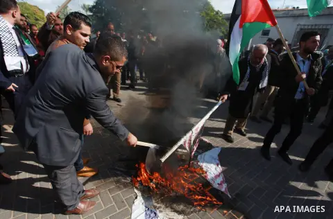 Palestinian protesters burn US and Israeli flags following Trump's decision to recognise Jerusalem as the capital of Israel, in front of the headquarter United Nation "UNSCO" in Gaza City, on December 7, 2017. Photo by M...