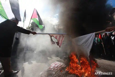 Palestinian protesters burn US and Israeli flags following Trump's decision to recognise Jerusalem as the capital of Israel, in front of the headquarter United Nation "UNSCO" in Gaza City, on December 7, 2017. Photo by M...