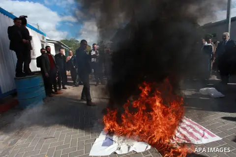Palestinian protesters burn US and Israeli flags following Trump's decision to recognise Jerusalem as the capital of Israel, in front of the headquarter United Nation "UNSCO" in Gaza City, on December 7, 2017. Photo by M...
