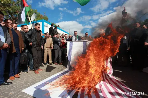 Palestinian protesters burn US and Israeli flags following Trump's decision to recognise Jerusalem as the capital of Israel, in front of the headquarter United Nation "UNSCO" in Gaza City, on December 7, 2017. Photo by M...